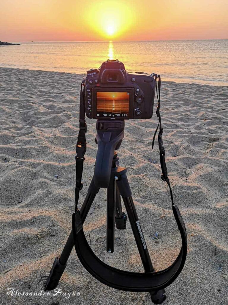 fotocamera su treppiede durante tramonto sulla spiaggia